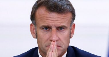 President Emmanuel Macron with hands clasped.