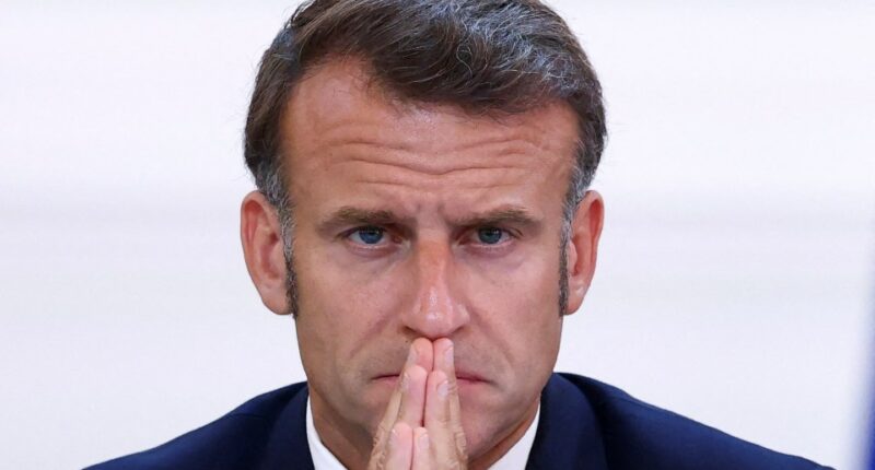 President Emmanuel Macron with hands clasped.