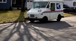 US Post Office truck parked on a residential street.