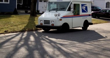 US Post Office truck parked on a residential street.
