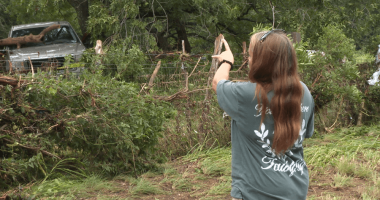 Leander woman shows the tree she climbed to survive floods during the early morning hours of July 5, 202
