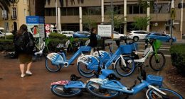 Pedestrians walk past e-bikes near the NSW State Library in Sydney.
