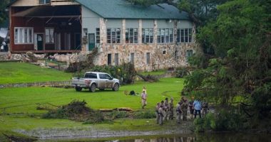 Officials search on the grounds of Camp Mystic on Sunday in Hunt, Texas.