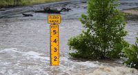 A flood gauge marks the height of water flowing over a farm-to-market road near Kerrville, Texas.