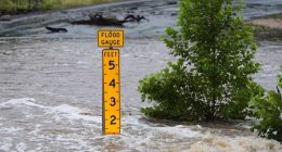 A flood gauge marks the height of water flowing over a farm-to-market road near Kerrville, Texas.
