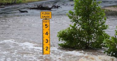 A flood gauge marks the height of water flowing over a farm-to-market road near Kerrville, Texas.