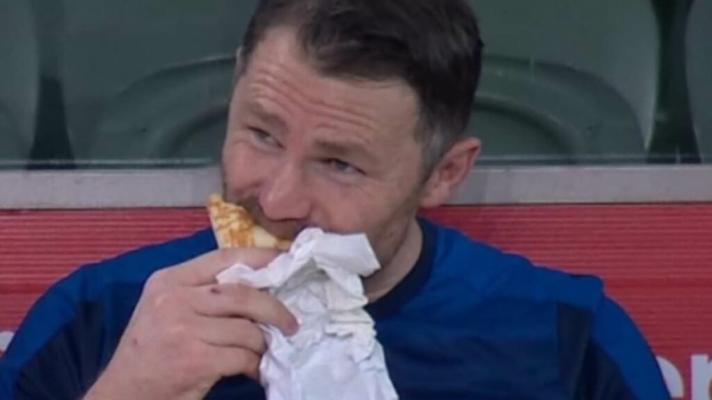 Footy superstar gets slammed by fans as he's caught eating a KEBAB in the middle of a match
