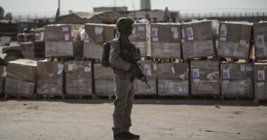 FILE - An Israeli soldier stands beside humanitarian aid packages awaiting pickup on the Palestinian side of the Kerem Shalom crossing in the Gaza Strip, Thursday, July 24, 2025, during a media tour organized by the Israeli army. (AP Photo/Ohad Zwigenberg, file)