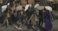Palestinians carry sacks of flour unloaded from a humanitarian aid convoy that reached Gaza City from the northern Gaza Strip.