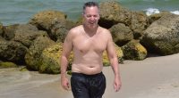 Paunchy Fox News star Greg Gutfeld shows his softer side as he soaks up sun with wife and newborn daughter