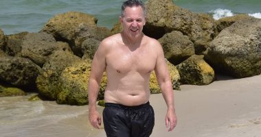 Paunchy Fox News star Greg Gutfeld shows his softer side as he soaks up sun with wife and newborn daughter