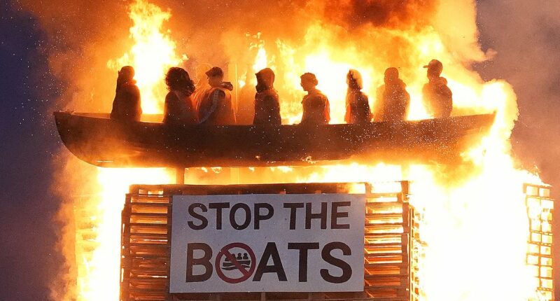 Police launch hate crime investigation as 'vile and racist' effigy of small boat migrants is burned on top of Northern Ireland bonfire