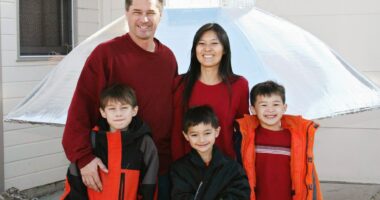 The Heene family smiles together in coordinating red outfits.