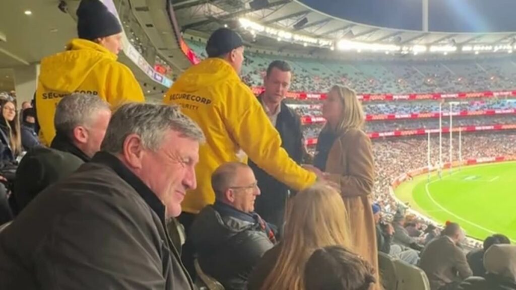 See the moment security has to step in and save Channel Seven star as he gets caught up in a heated clash with a rival fan at the footy