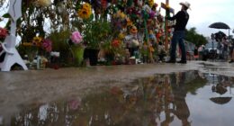 Roberto Marquez places a cross at a memorial wall for flood victims, Sunday, July 13, 2025, in Kerrville, Texas. (AP Photo/Eric Gay)