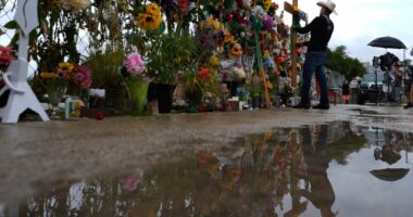 Roberto Marquez places a cross at a memorial wall for flood victims, Sunday, July 13, 2025, in Kerrville, Texas. (AP Photo/Eric Gay)