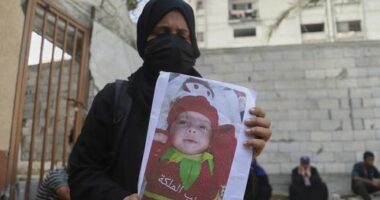 Esraa Abu Halib shows to journalists a photo of her 5-month-old baby, Zainab, who died from malnutrition-related causes, according to the family and the hospital, as she stands outside the Nasser Hospital, in Khan Younis, Gaza Strip, Saturday, July 26, 2025. (AP Photo/Mariam Dagga)