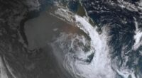 The thick cloud coverage is visible from space, with a clear crescent storm system floating above the East Coast.