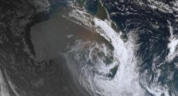 The thick cloud coverage is visible from space, with a clear crescent storm system floating above the East Coast.