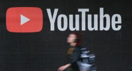 A young woman wearing headphones walks past a billboard advertisement for YouTube on September 27, 2019 in Berlin, Germany. YouTube has evolved as the world's largest platform for sharing video clips. (Photo by Sean Gallup/Getty Images)