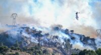 Helicopter dropping water on a wildfire.