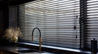 Black wooden blinds in a modern kitchen.