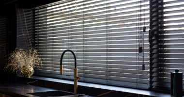 Black wooden blinds in a modern kitchen.