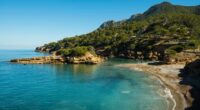 Secluded cove with clear turquoise water and a small beach.