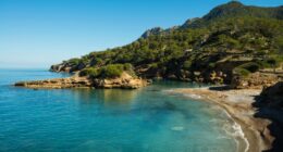 Secluded cove with clear turquoise water and a small beach.