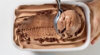 chocolate ice cream is scooping out of container, top view