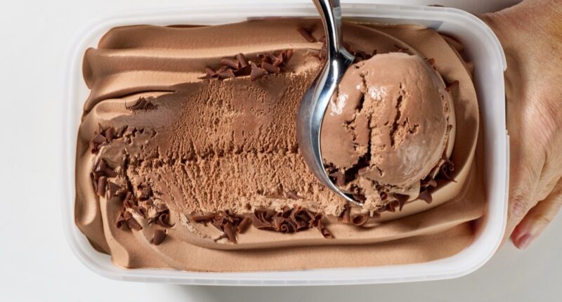 chocolate ice cream is scooping out of container, top view
