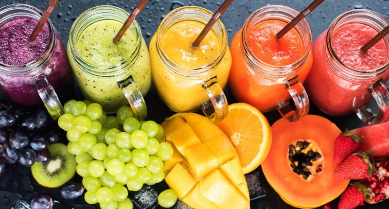 Fresh Color Juices Smoothie Violet Green Yellow Orange Red from Tropical Fruits Kiwi Water Melon Strawberry Apple Orange Banana Pine Apple Mango Pomegranate Grape Bottles Rainbow Dark Background