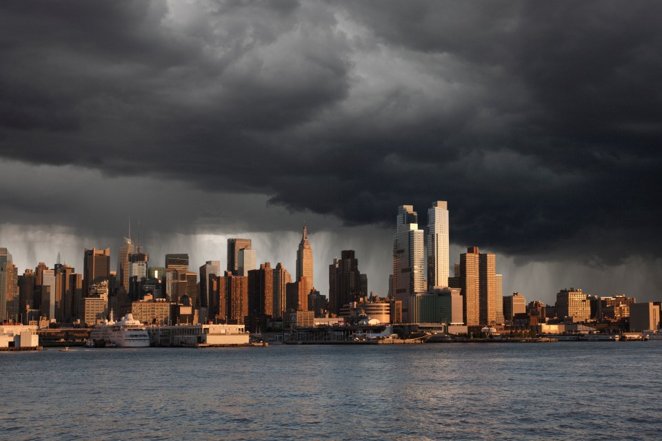 City skyline with storm clouds overhead.