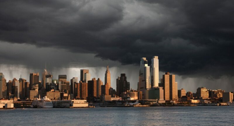 City skyline with storm clouds overhead.