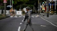 Soldier patrolling a street after a bombing.