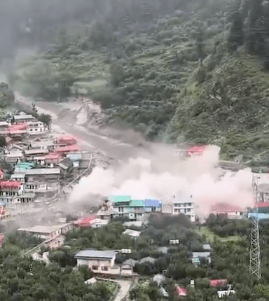 Floodwaters inundating a village in a mountainous region.