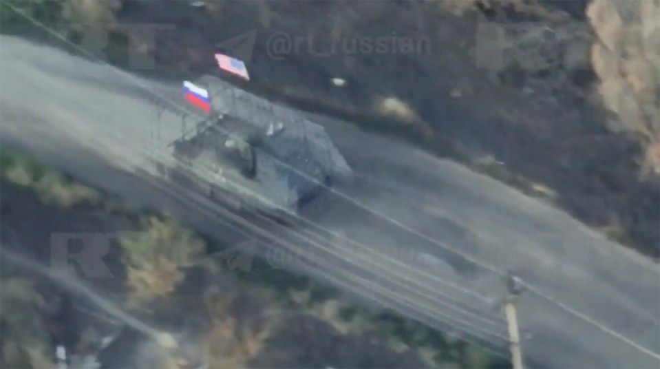 Aerial view of a captured US M113 armored personnel carrier with Russian and US flags.