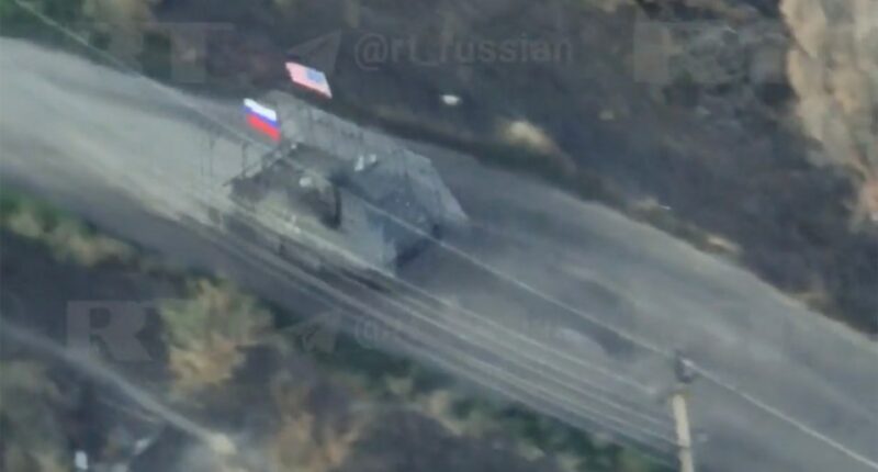 Aerial view of a captured US M113 armored personnel carrier with Russian and US flags.