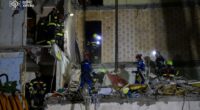 Rescuers searching for survivors in a damaged apartment building.