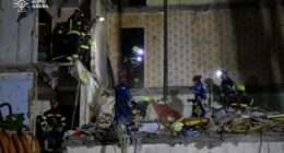 Rescuers searching for survivors in a damaged apartment building.