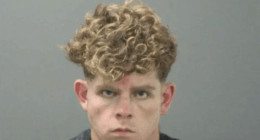 Mugshot of a young man with curly blond hair.