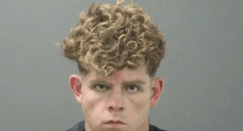 Mugshot of a young man with curly blond hair.