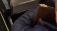 Person on airplane with a book.
