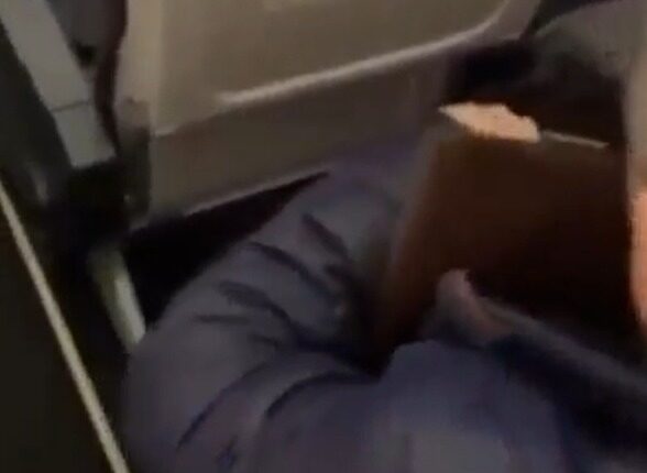 Person on airplane with a book.