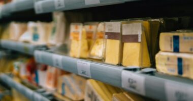 Variety of cheese on supermarket shelves.