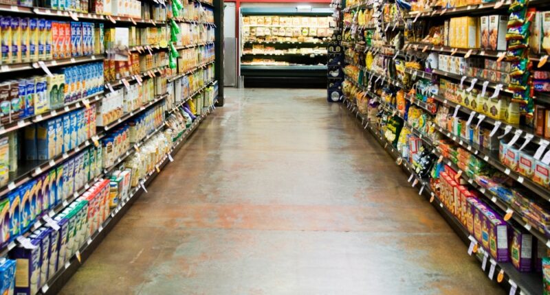 Grocery store aisle with shelves stocked with food.