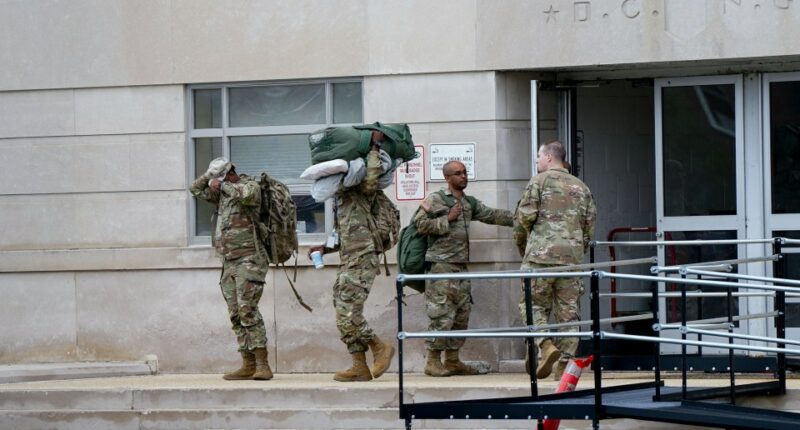 U.S. National Guard members carrying gear.