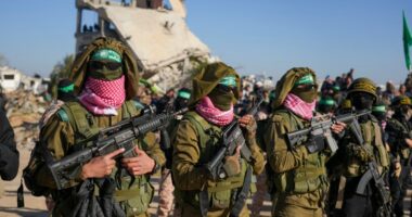Hamas fighters stand in formation ahead of a hostages' release in Khan Younis, Gaza Strip, Saturday, Feb. 15, 2025. (AP Photo/Abdel Kareem Hana)