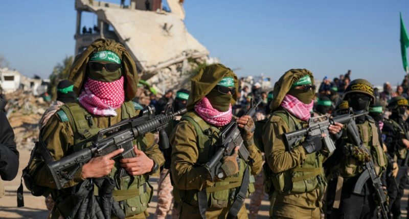 Hamas fighters stand in formation ahead of a hostages' release in Khan Younis, Gaza Strip, Saturday, Feb. 15, 2025. (AP Photo/Abdel Kareem Hana)
