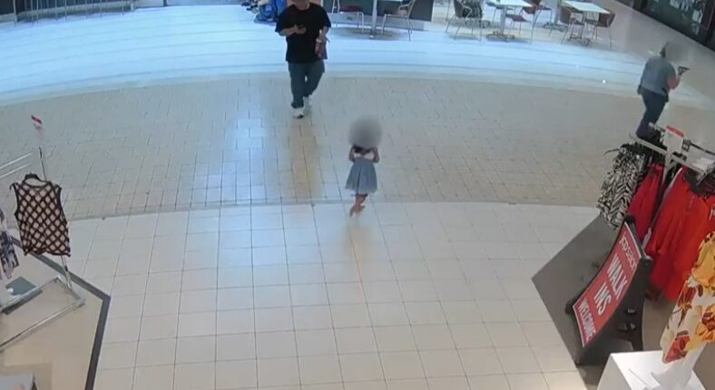 Security camera footage of a young girl walking alone in a mall.